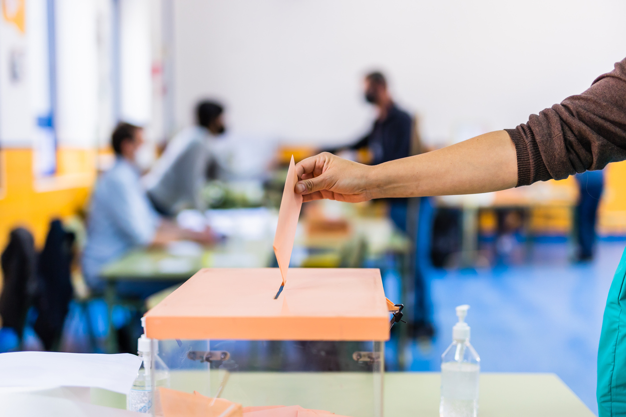 Autonomous community of Madrid elections. Democraty referendum for government vote. Hand posing an envelop in a ballot box for community elections